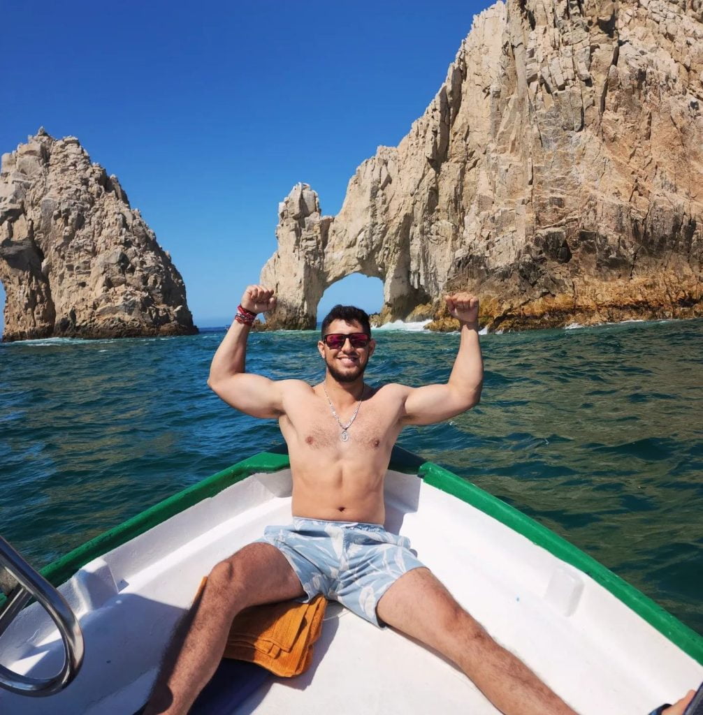 Muchacho en bañador visitando El Arco de Cabo San Lucas, Baja California Sur