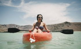 Mujer en bikini disfrutando de Playa Balandra en un kayak